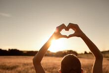 Girl With Heart Up To The Sun. Love, Wellbeing, And Inner Happiness Concept.