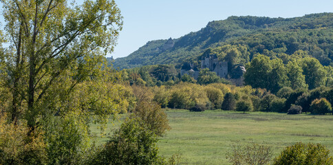 Wall Mural - looking across a valley with grass meadows and distant woodland hills with clear blue sky