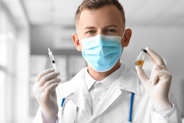 Wall Mural - Male doctor in medical mask with syringe and ampule at hospital, closeup