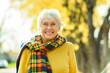 © Louis-Photo - Happy elderly senior woman in an autumn park.