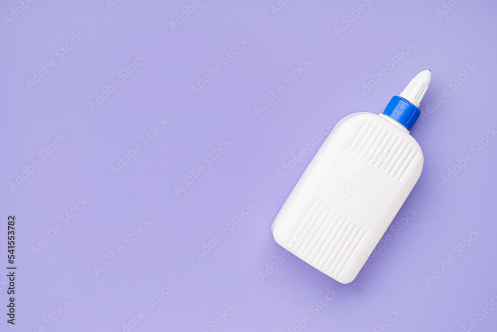 Bottle of glue on lilac background