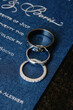 Close up silver rings of bride and groom lying on blue wedding envelope