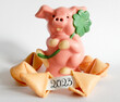 Leinwandbild Motiv Rosa Schweinchen aus Schokolade mit Kleeblatt und Glückskekse, ein Glückskeks geöffnet mit Datum 2023 auf den Papierstreifen,
Silvester und Glücksbringer Karte,

