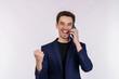 © Johnstocker - Portrait of happy handsome businessman talking by mobile phone and doing winner gesture clenching fist isolated over white background