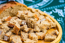 Close-up Of A Brown Sourdough Loaf And Cubes Of Bread On A Traditional Georgian Tablecloth