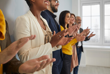 Close up of diverse multiracial businesspeople clap hands meet welcome coach or presenter at briefing. Multiethnic employees applaud show acknowledgement or appreciation at business training.