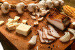 still life of food in a rural style on a dark wood background, sliced lard and garlic, cheese, corn and onion, concept of fresh vegetables and healthy food
