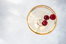 Overhead View Of A Glass Of Champagne With Fresh Raspberries
