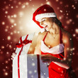 © yurolaitsalbert - surprised young woman in costume of Santa Claus opening a Christmas gift.