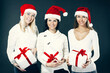 © yurolaitsalbert - three young women in costume of Santa Claus with Christmas shopping