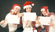 © yurolaitsalbert - three young girls in costume of Santa Claus showing blank sheets