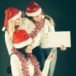 © yurolaitsalbert - three young girls in costume of Santa Claus showing blank sheets