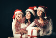 © yurolaitsalbert - group of happy women in costumes of Santa Claus and Christmas shopping .