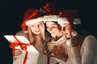 © yurolaitsalbert - group of female students in costumes of Santa Claus opening a box of Christmas gifts .