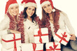 © yurolaitsalbert - closeup.three young women in hats of Santa Claus with Christmas gifts.
