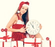 © yurolaitsalbert - beautiful young woman in Christmas suit with a clock sitting on the boxes with Christmas gifts.