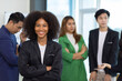 © Wasan - Portrait of a charming African businesswoman in a business office meeting room while working with multi-ethnic colleagues.