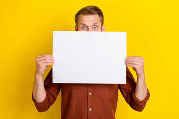 Poster - Photo of interesting boy man dressed stylish brown clothes arm hold paper sheet cover face empty space isolated on yellow color background