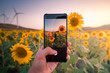 © ADDICTIVE STOCK - Anonymous person taking photo of sunflower field during sunset