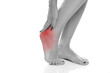 © vladimirfloyd - woman holding her painful heel and foot on white studio backgrou