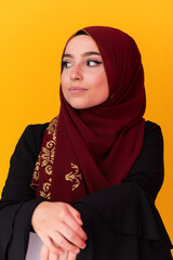 beautiful muslim woman in fashinable dress with hijab isolated on modern yellow background representing concept of modern islam and ramadan kareem