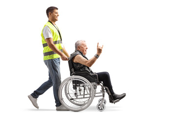 Canvas Print - Full length profile shot of a community worker pushing a punk in a wheelchair