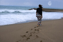 Mujer Caminando Por La Orilla Del Mar Dejando Huellas