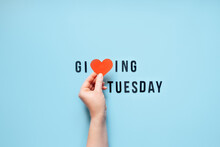 Giving Tuesday, Give, Help, Donation, Support, Volunteer Concept With Red Heart In Female Hands And Text Giving Tuesday On Blue Background. Its Time To Give