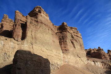 Wall Mural - A huge sheer wall in the sandy-clay canyon of Charyn against the background of the sky with beautiful thin clouds in sunny weather