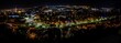 Panoramic night cityscape view with illuminated Cluj-Napoca city and trees