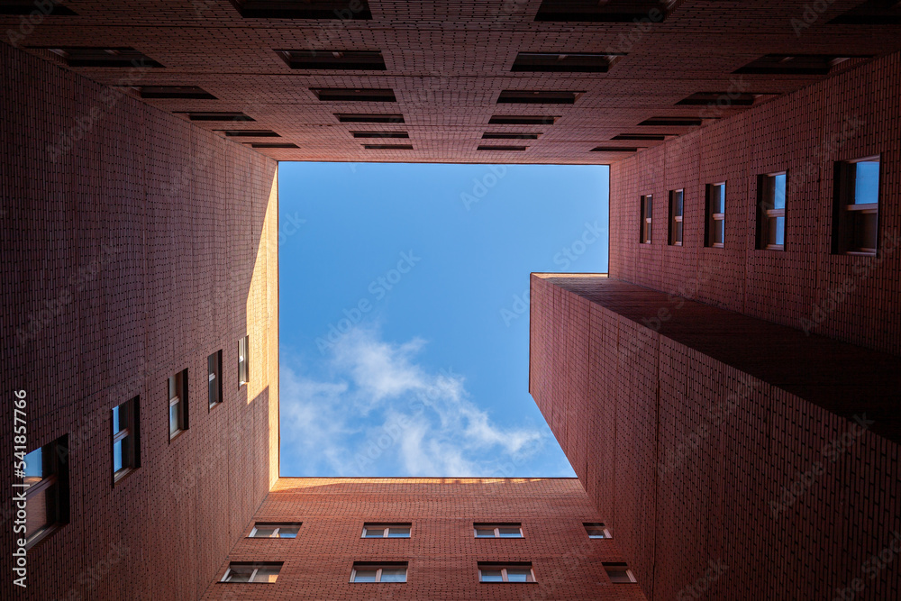 Brick high-rise new square house on a blue sky background. View from ...