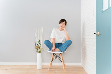 Wall Mural - 部屋で椅子に座りながら悩むストレスを抱えたアジア人女性
