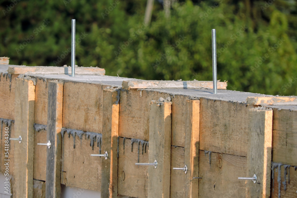 A reinforced concrete beam, steel pins and a wooden formwork on the ...