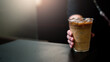 © pariwatpannium - hand holding a take-out iced coffee on black table