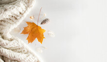 Autumn Or Winter Composition On A White Background. Dry Leaves And White Blanket. Top View, Flat Lay, Copy Space