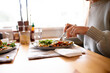 © Austockphoto - Close up shot of a woman eating a healthy vegetable dish and salad