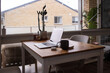 © Austockphoto - table at home  with an open laptop, mug, airpods and cactus plant