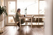 © Austockphoto - Woman working from home at kitchen table on laptop