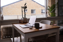 Table At Home  With An Open Laptop, Mug, Airpods And Cactus Plant