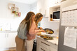 © Austockphoto - Happy female same sex couple cooking together and being affectionate in the kitchen