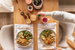 © Austockphoto - Top shot of a woman sitting at dining table with two plates of healthy vegetable based meal