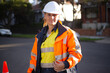© Austockphoto - Close up shot of a woman road worker with white helmet and orange jacket with a silver reflector