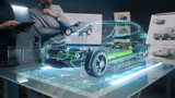 Fototapeta  - Car design engineers using holographic app in digital tablet. Develop modern innovative high-tech cutting edge eco-friendly electric car with sustainable standards. They test the aerodynamic qualities