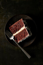 Chocolate Cake On Plate With Fork On Black Surface