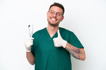 Wall Mural - Young caucasian dentist man isolated on white background giving a thumbs up gesture