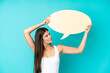 © luismolinero - Young Brazilian woman isolated on blue background holding an empty speech bubble and with sad expression