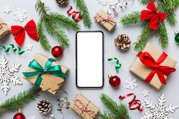 Digital phone mock up with rustic Christmas decorations for app presentation top view with empty space for you design. Christmas online shopping concept. Tablet with copy space on colored background