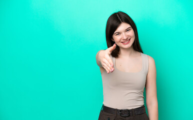 Wall Mural - Young Russian woman isolated on green background shaking hands for closing a good deal