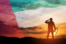 Silhouette Of Soldier Saluting On Background Of UAE Flag And The Sunset Or The Sunrise. Concept Of National Holidays. Commemoration Day.