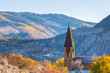 Aspen, Colorado ski resort town city chapel church bell tower building in autumn fall colorful foliage, early winter with snow in mountain valley